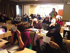 people in a darkened classroom holding up pieces to their eyes